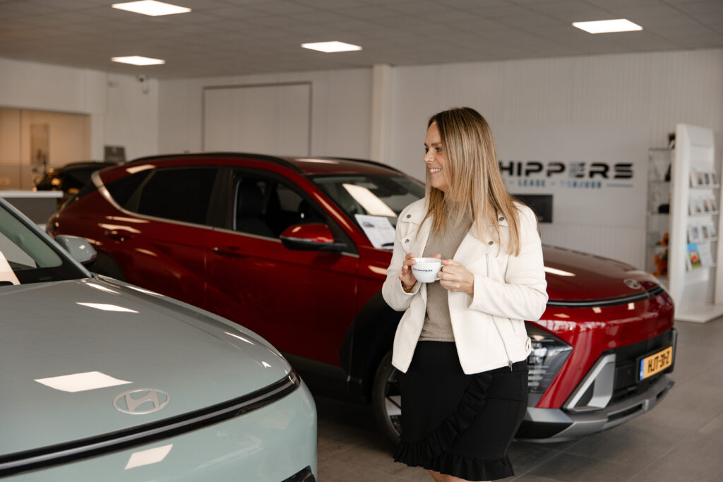 Tevreden klant met een kop koffie bij Autobedrijf Schippers Rijssen