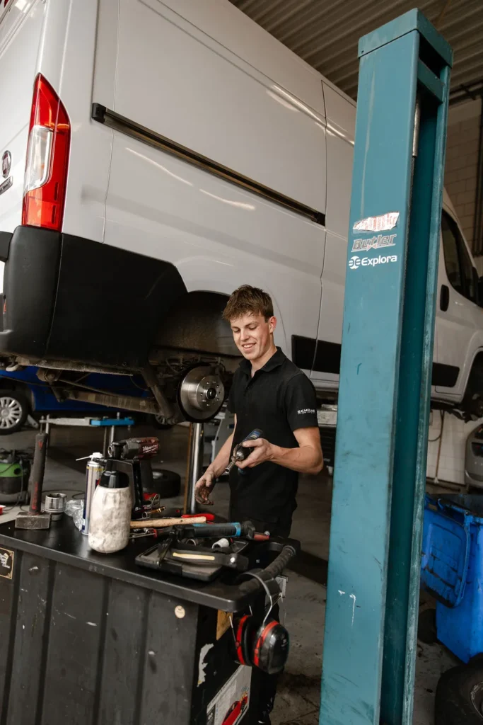 Automonteur werkt aan bus in werkplaats