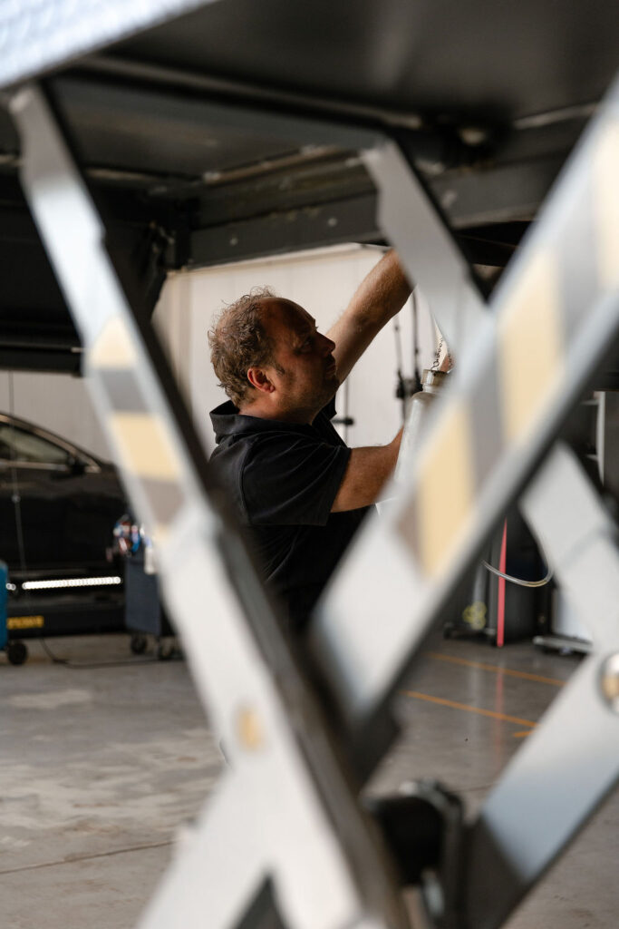 Monteur voert onderhoud uit aan auto in werkplaats van Autobedrijf Schippers Rijssen