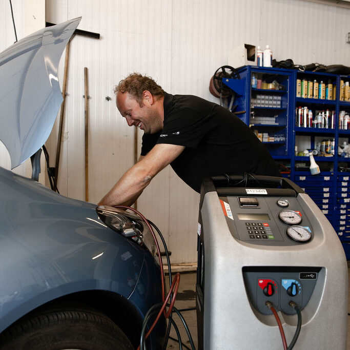 Monteur werkt aan de airco van een auto