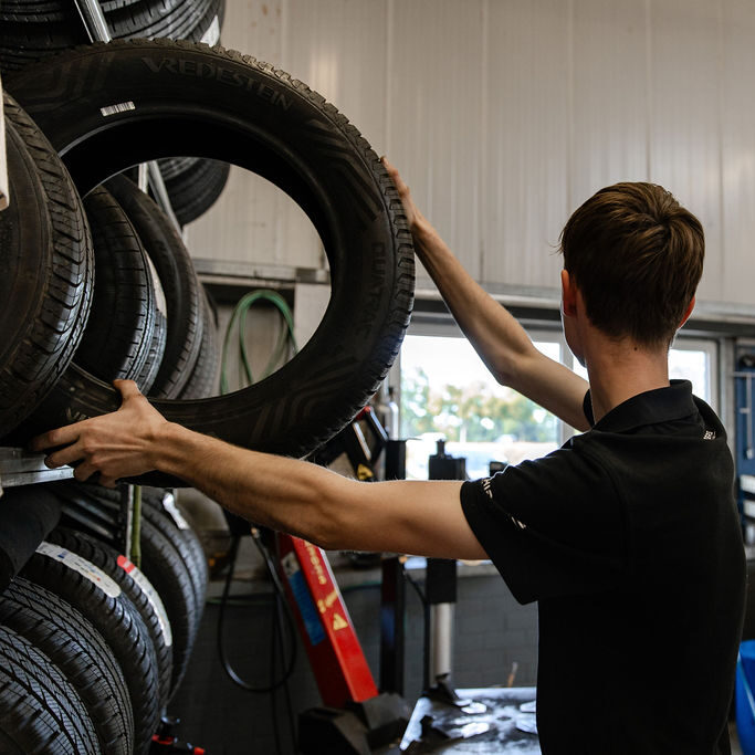 Monteur met een autoband in zijn handen