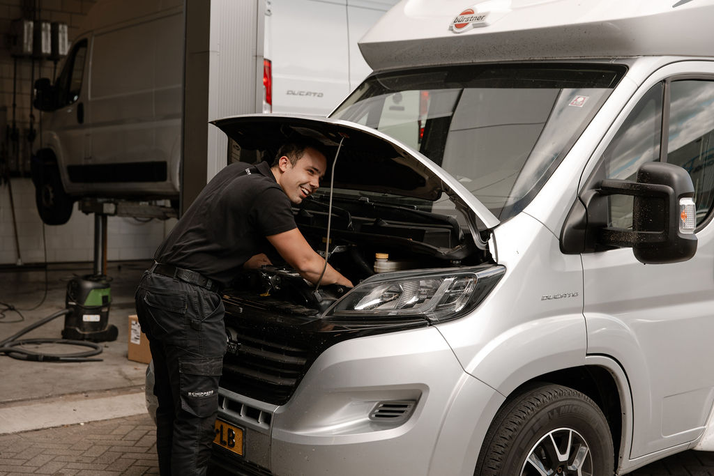 Een monteur voert onderhoud uit aan een camper