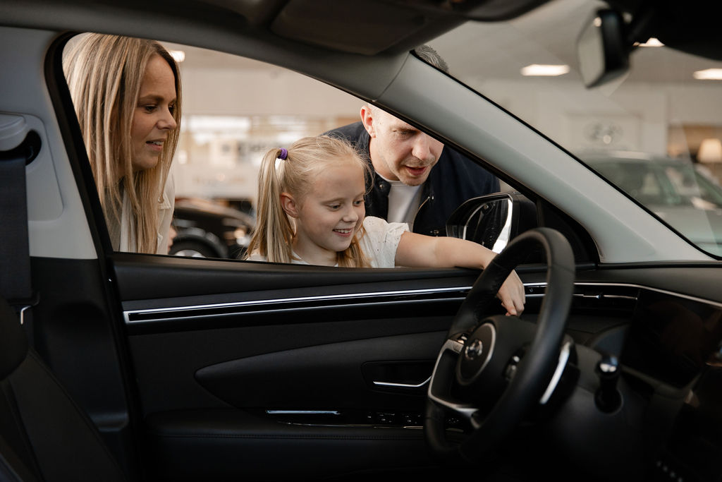 Tevreden klanten bekijken een auto bij Auto Schippers in Rijssen