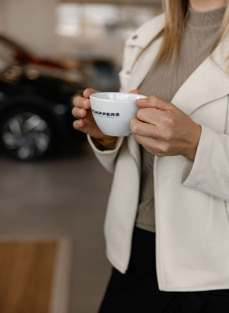Klant met een kop koffie bij Autobedrijf Schippers