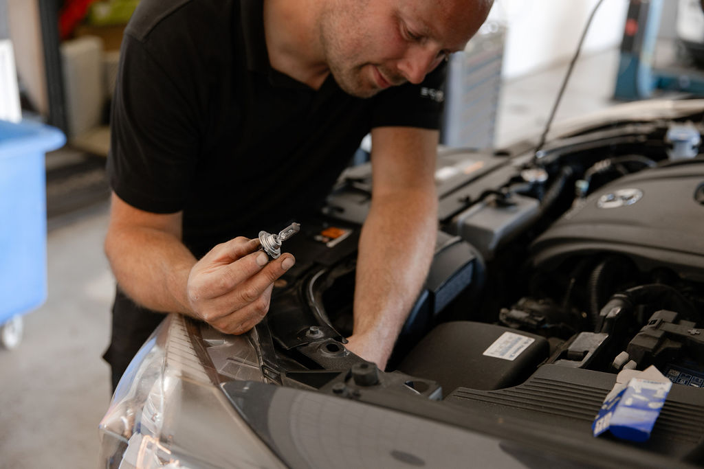 Monteur vervangt lampje van een auto