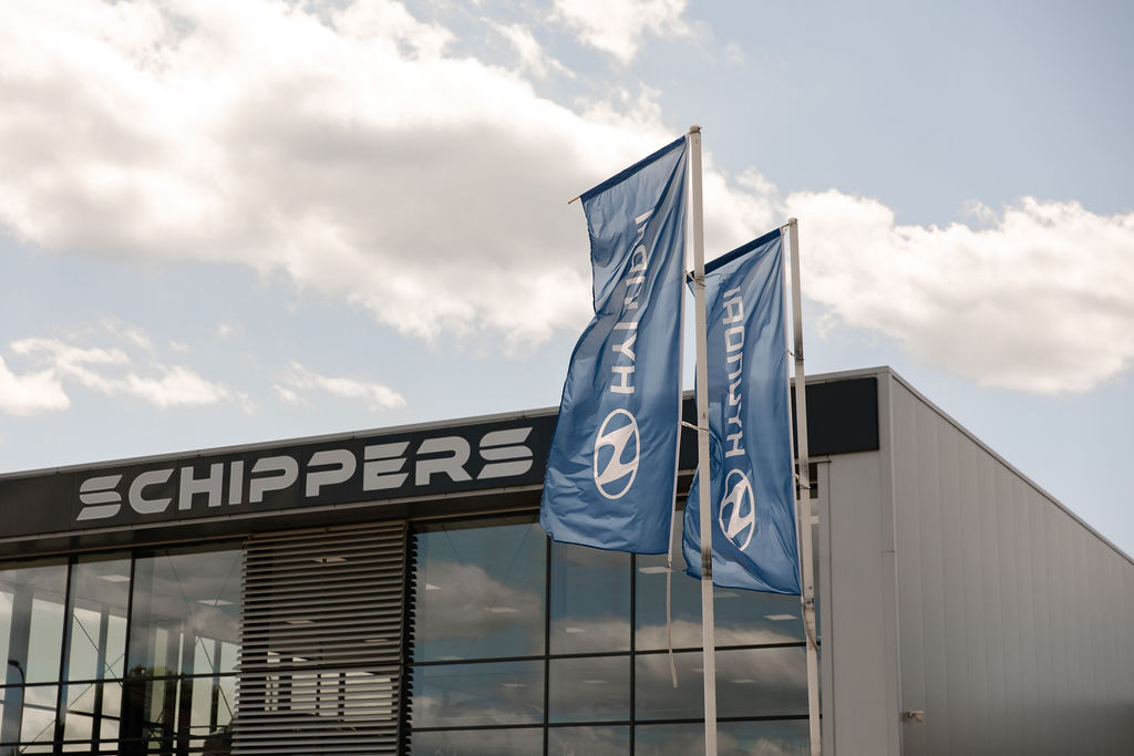 Bedrijfspand van Auto Schippers in Rijssen met Hyundai vlaggen