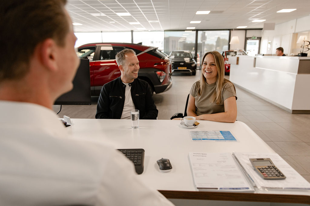 Klanten zijn in gesprek met een verkoper van Auto Schippers Rijssen